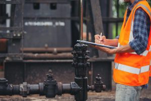 workers-standing-and-checking-beside-working-oil-pumps